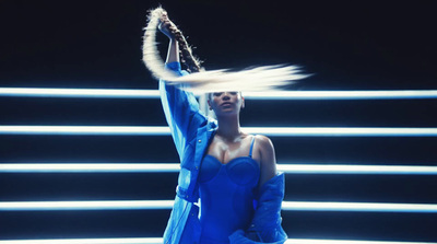 a woman in a blue dress holding a tennis racquet