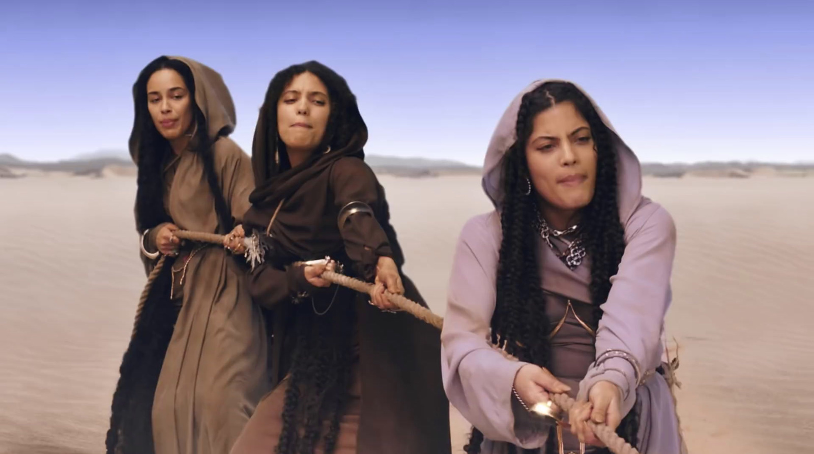 a group of women standing on top of a desert