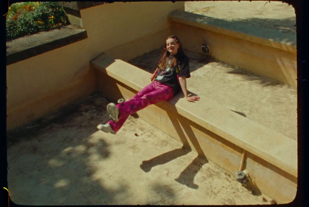 a girl sitting on a bench in a park