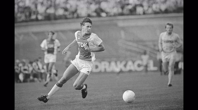 a man running after a soccer ball on a field