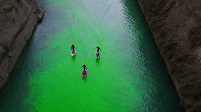 a group of people riding paddle boards on a river