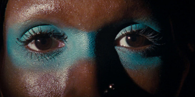 a close up of a woman's face with blue makeup