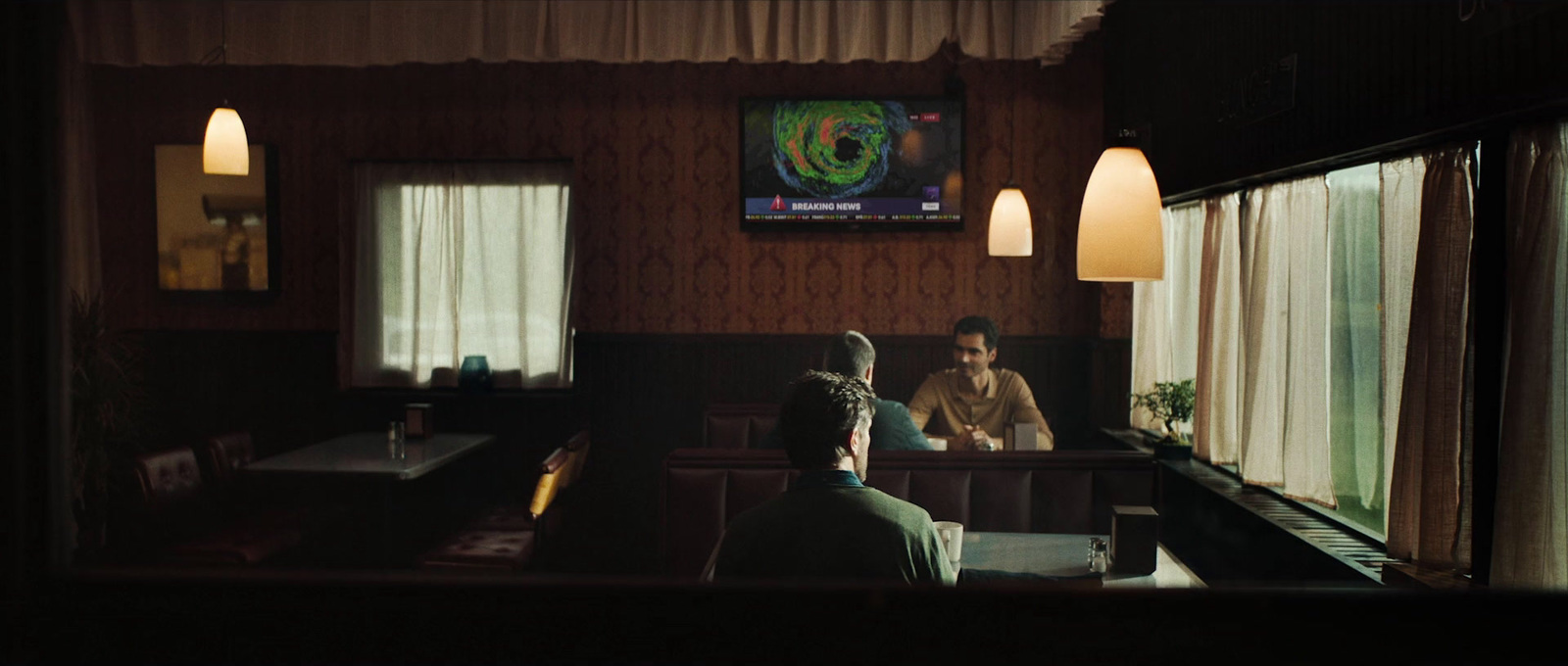 a couple of men sitting at a table in a restaurant