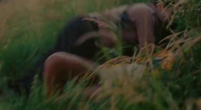 a man laying down in a field of tall grass