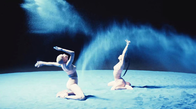 a couple of women are doing a dance on the beach