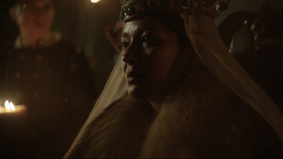 a woman in a fur coat with a crown on her head