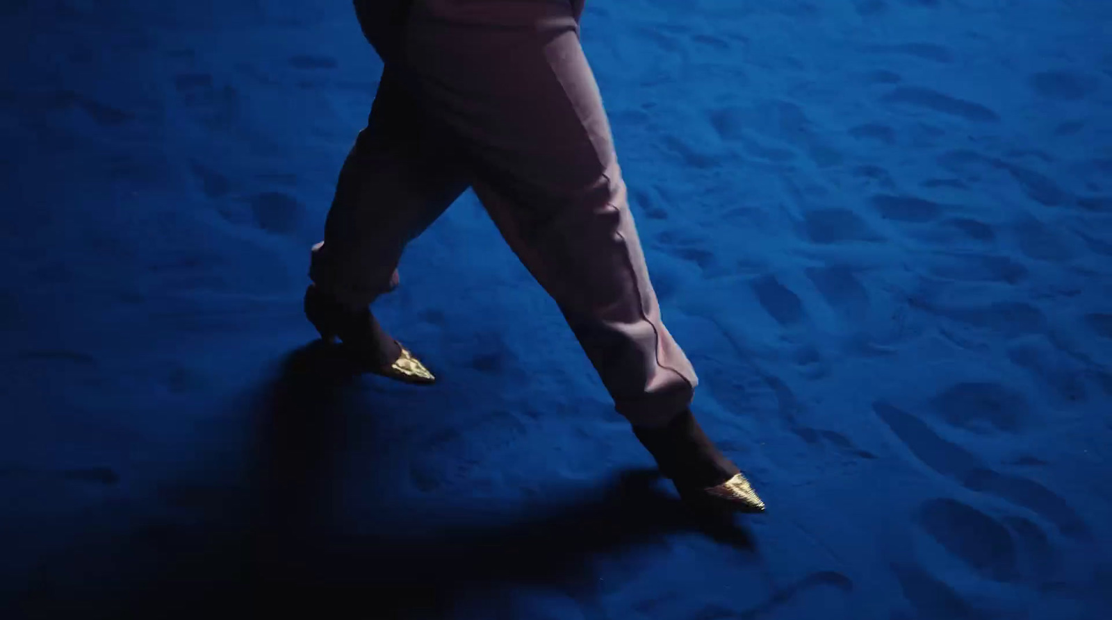 a woman in high heels walking on a blue carpet