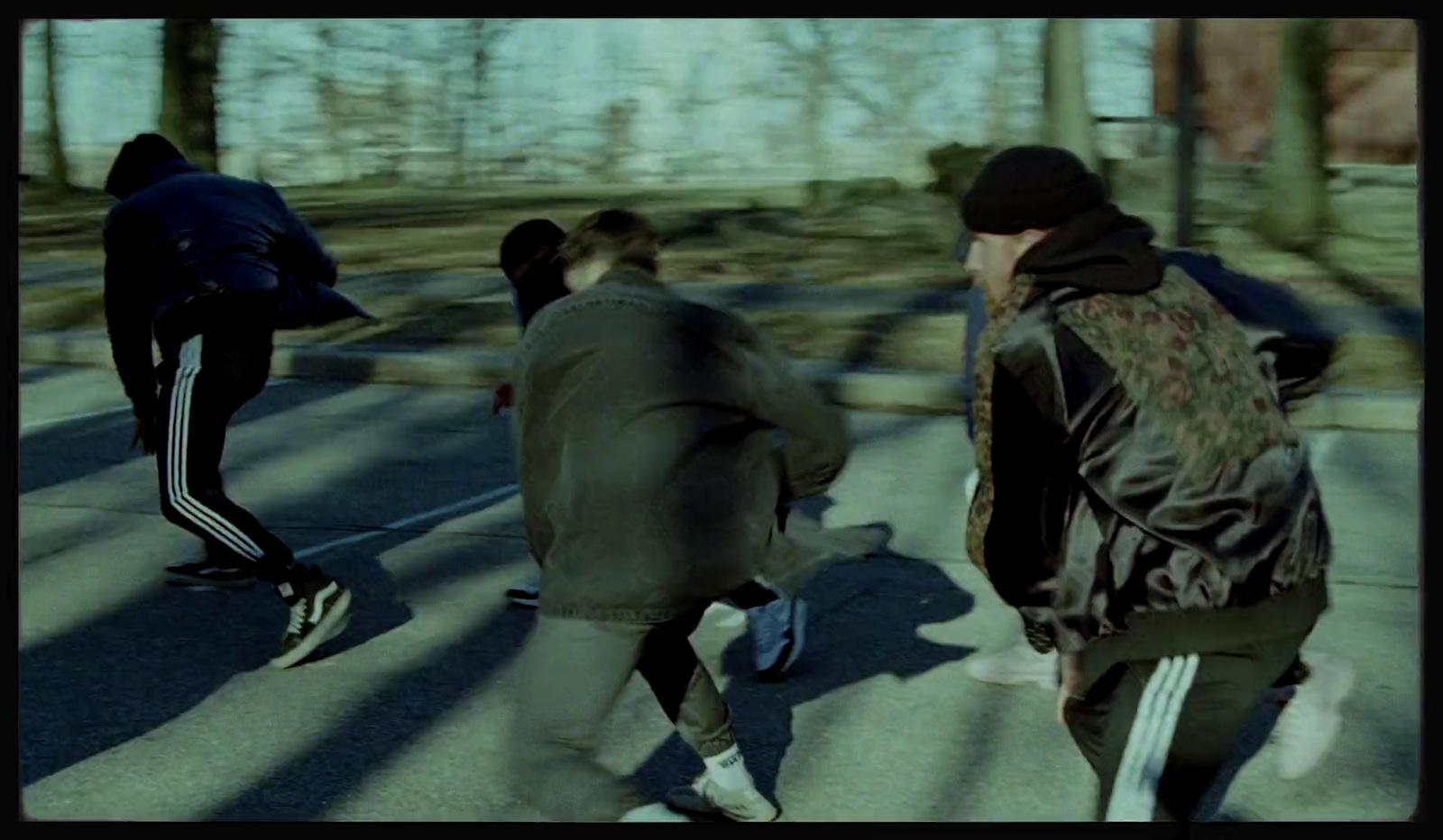 a group of young men riding skateboards down a street