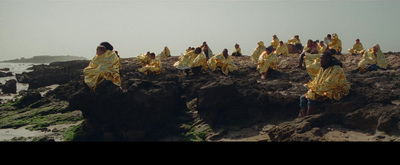 a group of people standing on top of a rocky beach