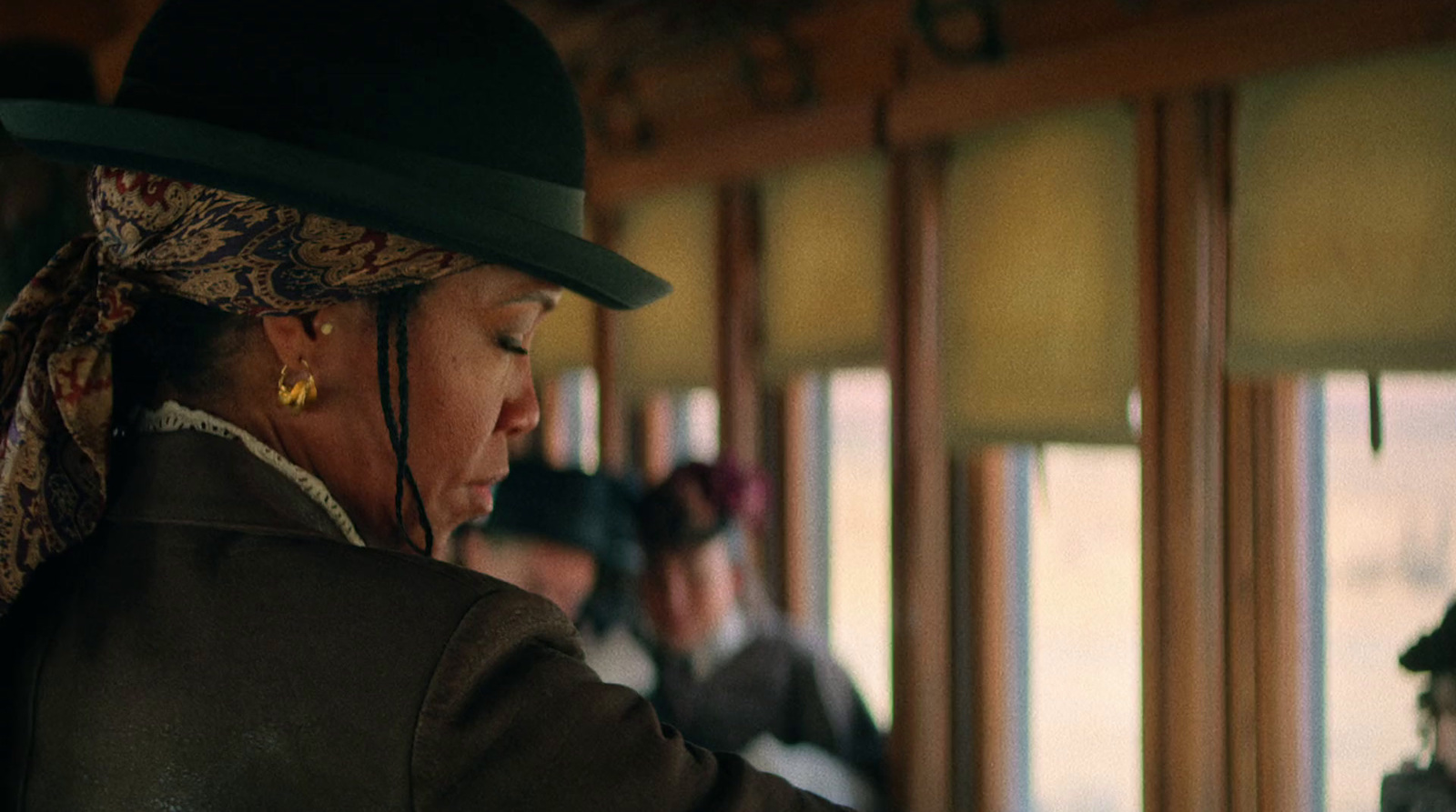 a woman wearing a hat and a scarf on a train