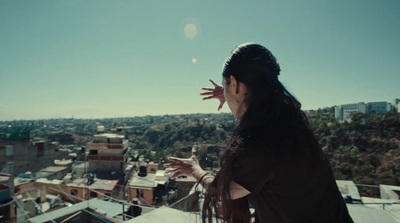 a woman standing on top of a roof with her hands in the air