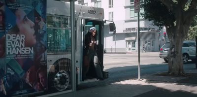 a woman getting out of a bus on a city street