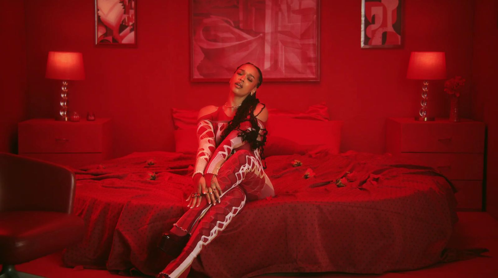 a woman sitting on a bed in a red room