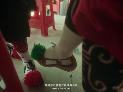 a person wearing sandals and a green pom pom