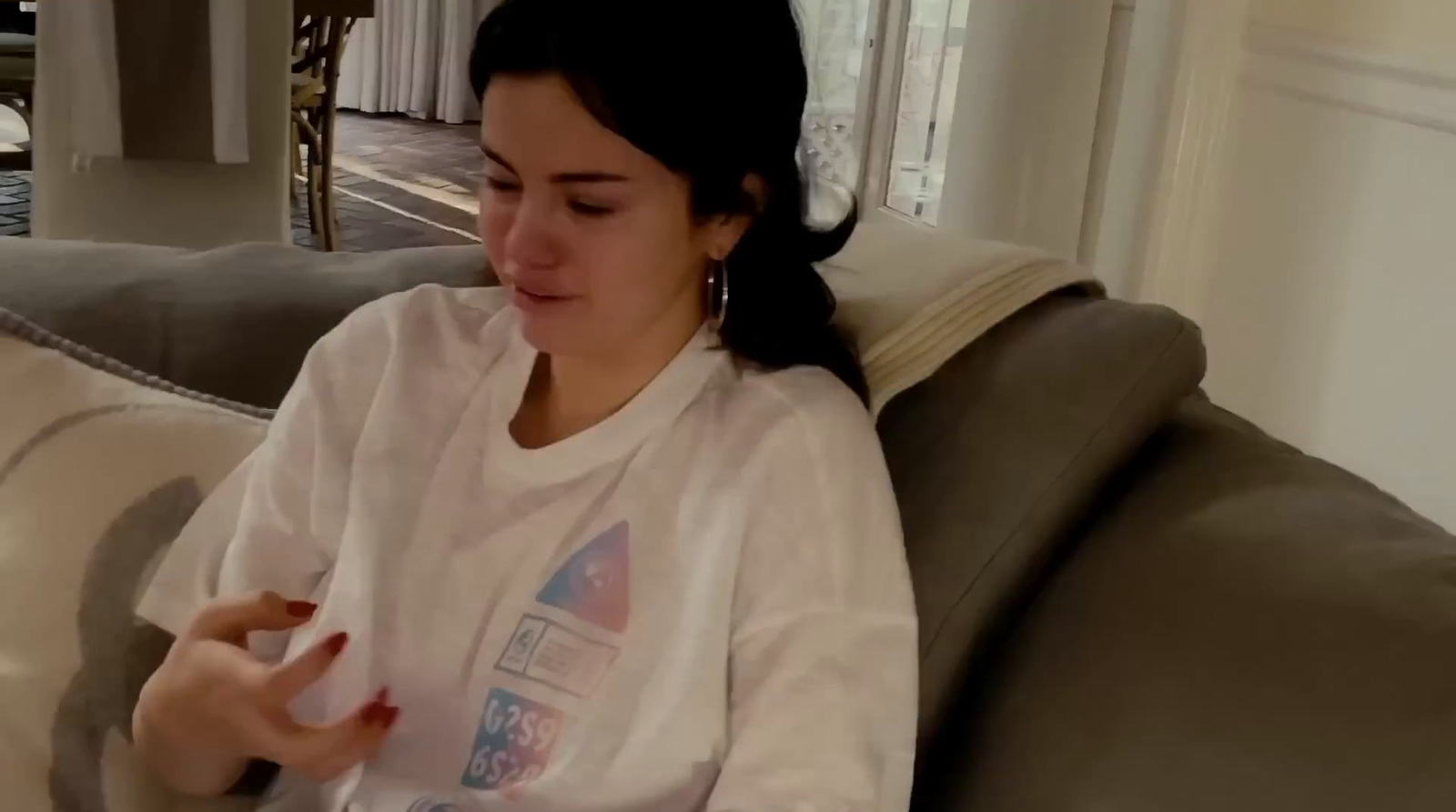 a woman sitting on a couch holding a cell phone