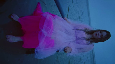 a girl in a pink dress laying on the ground