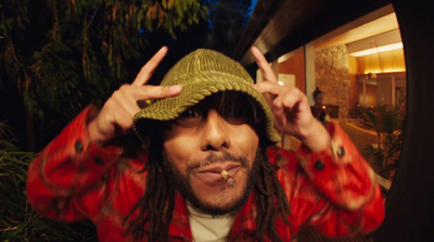 a man wearing a hat making a peace sign