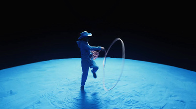 a man in a blue suit and hat is doing a trick with a hula