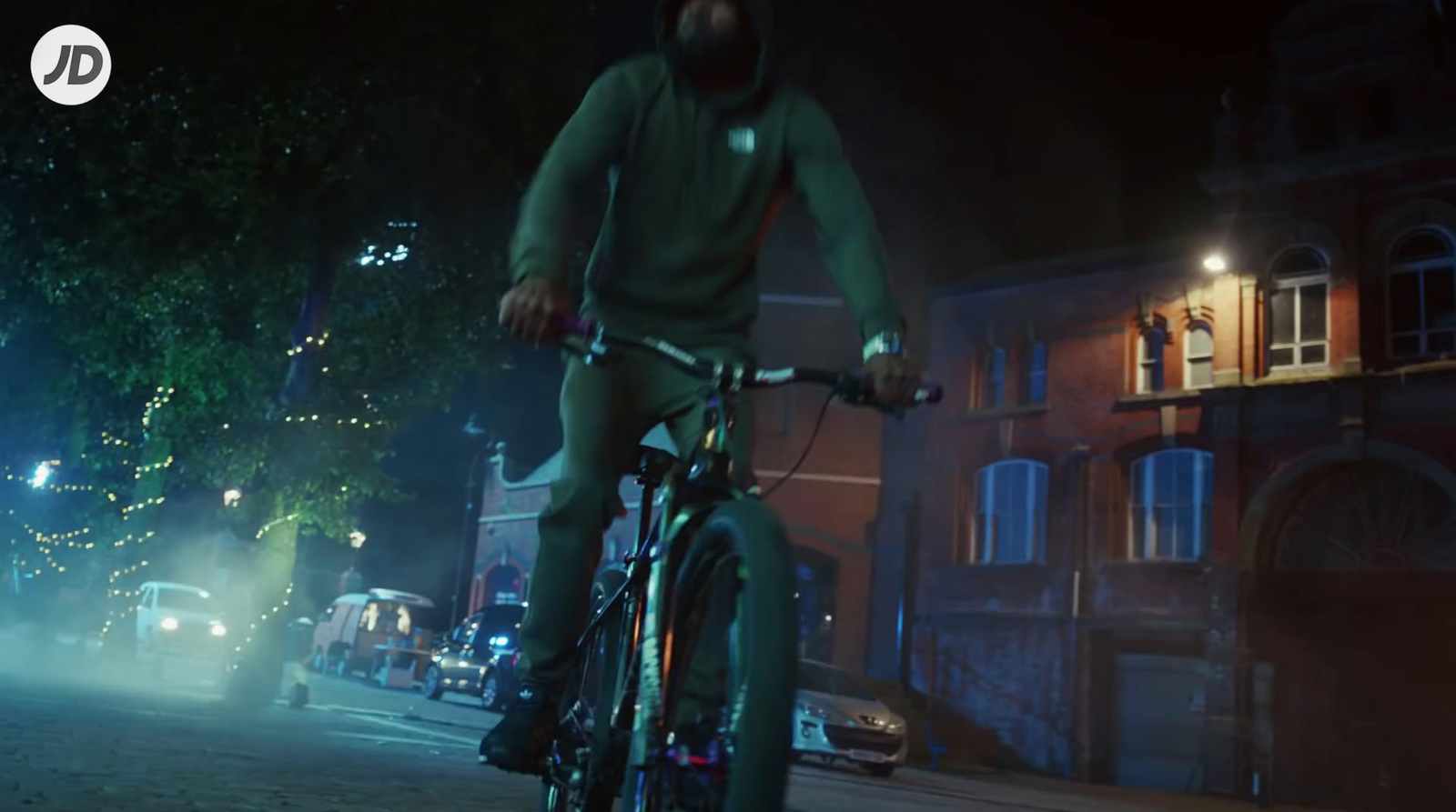 a man riding a bike down a street at night