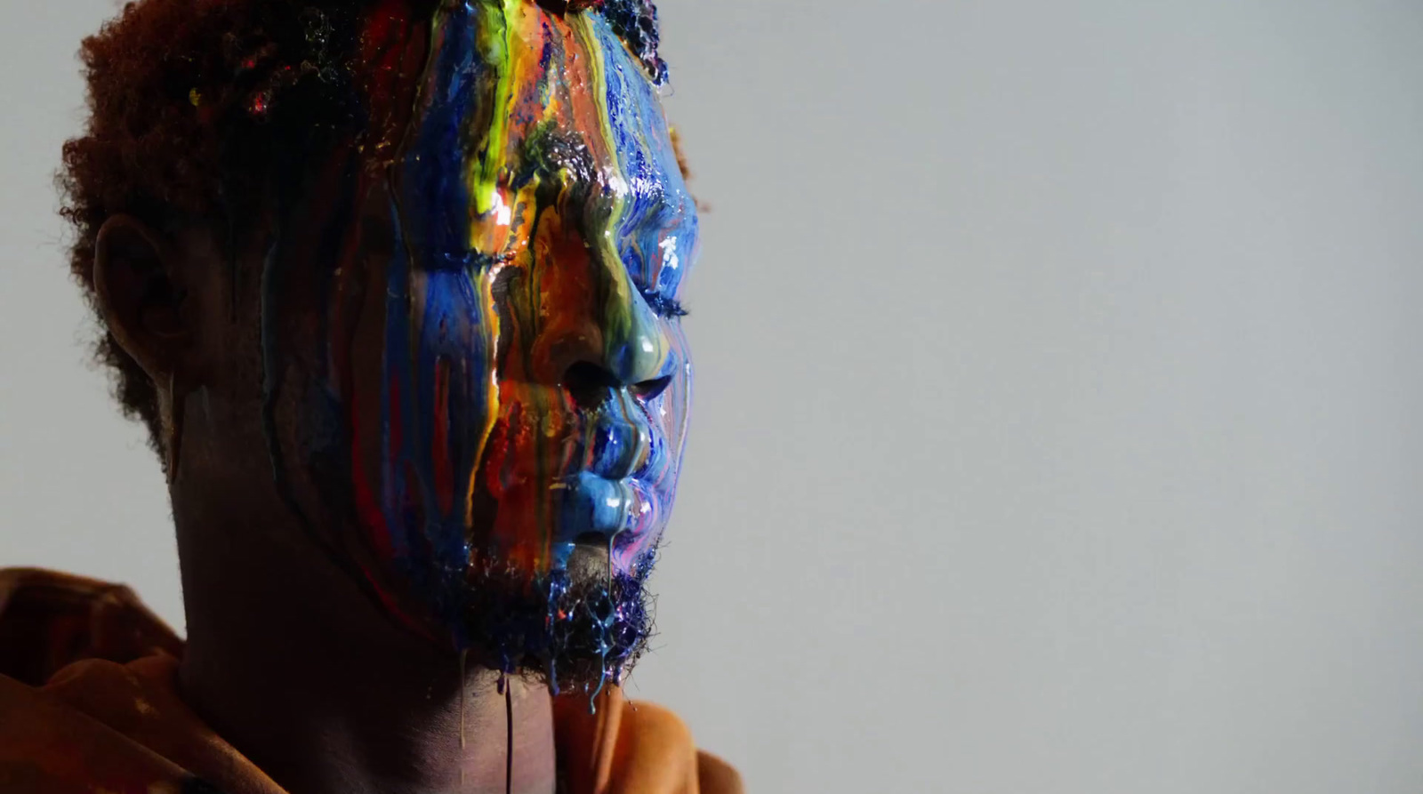 a man with his face covered in multicolored paint