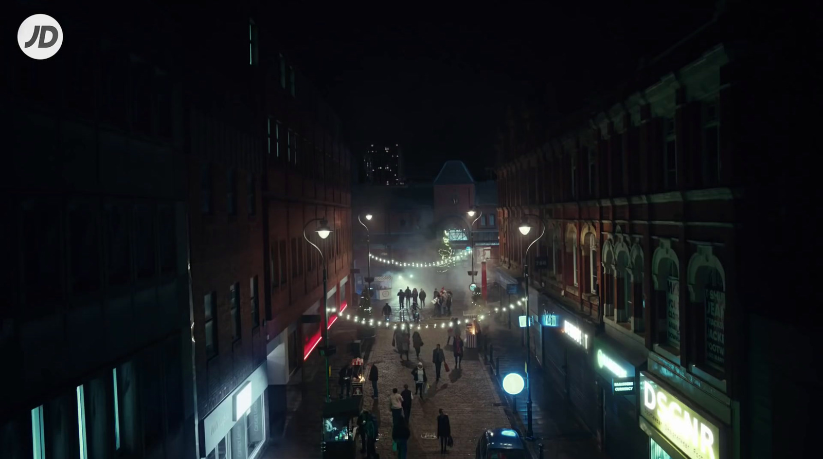 a city street at night with people walking around