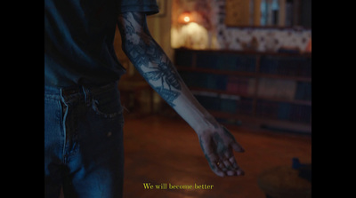 a man with a tattoo on his arm is holding out his hand