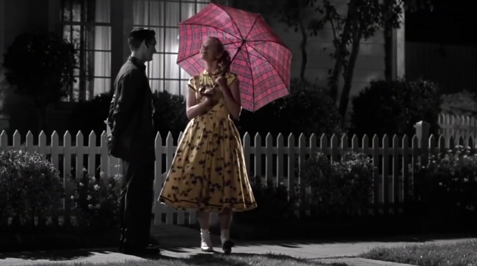 a woman in a dress holding a pink umbrella