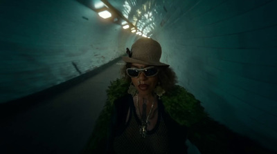 a woman wearing a hat and sunglasses in a tunnel