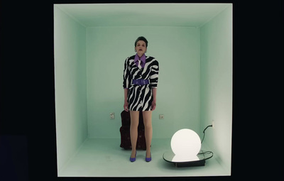 a woman standing in a room with a lamp