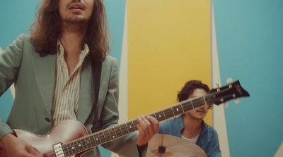 a man with long hair playing a guitar