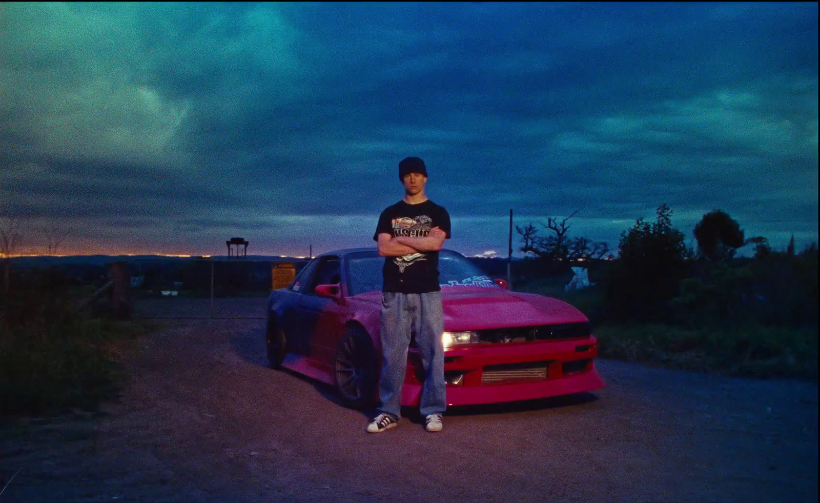 a man standing next to a red sports car