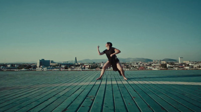 a woman in a swimsuit jumping on a dock