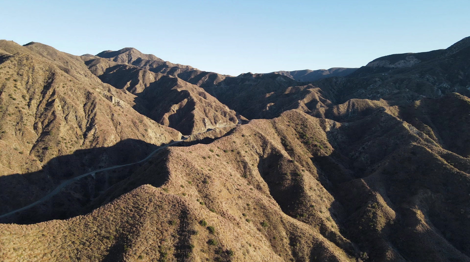 an aerial view of a winding road in the mountains