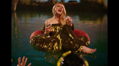 a woman in a gold dress sitting on a red chair