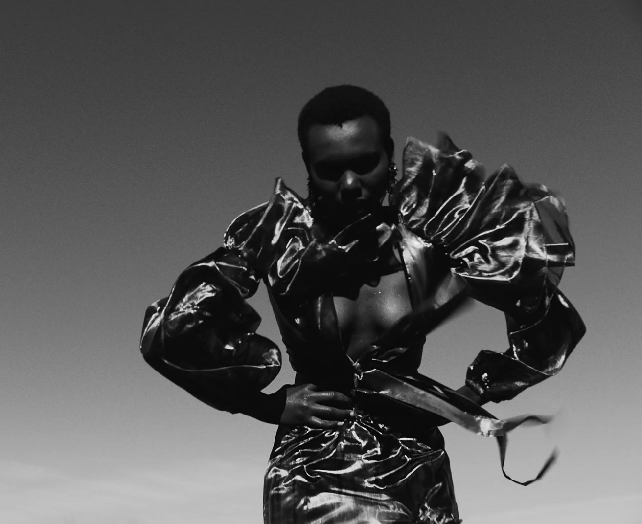 a man in shiny clothing holding a pair of scissors