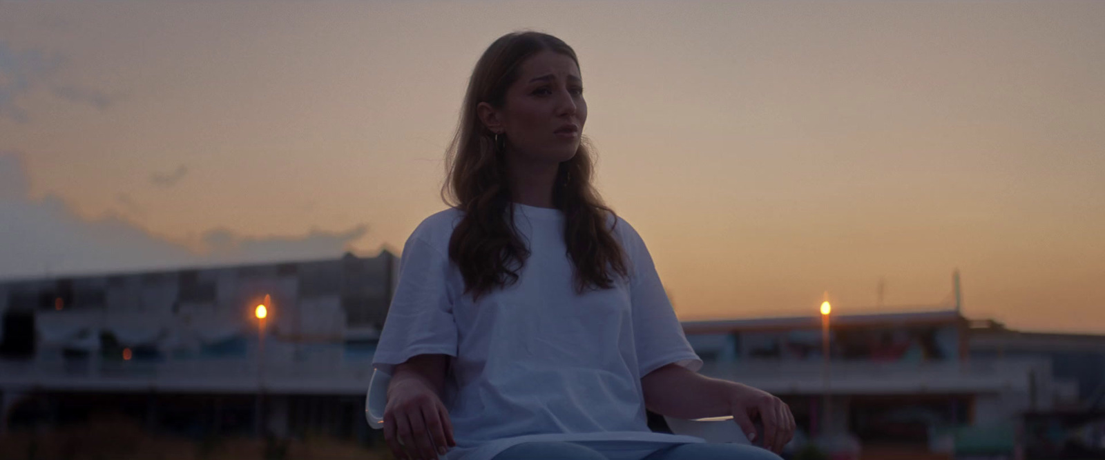 a woman sitting on top of a skateboard in front of a building