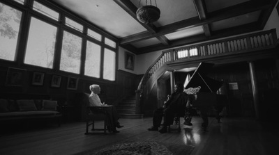 a man sitting in a chair in front of a piano