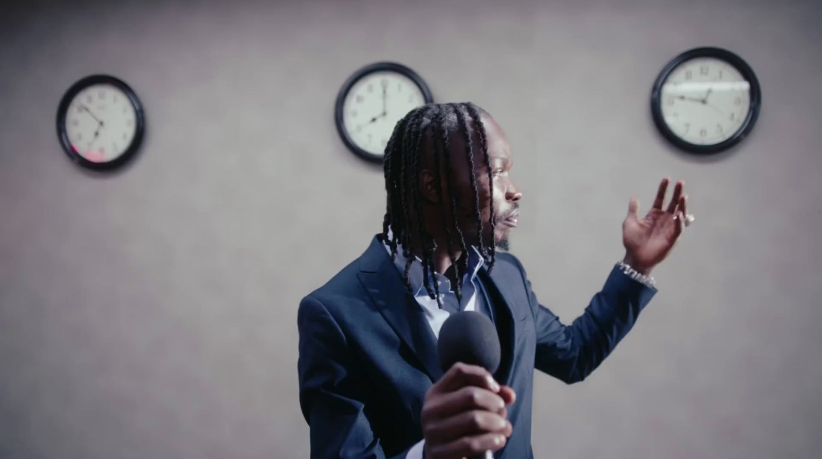 a man standing in front of three clocks