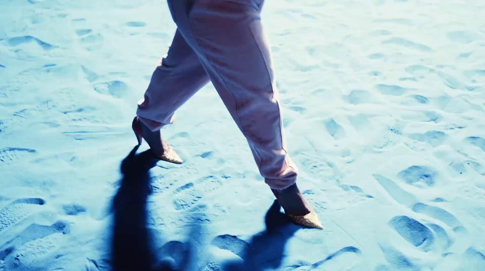 a person's legs and shoes in the snow