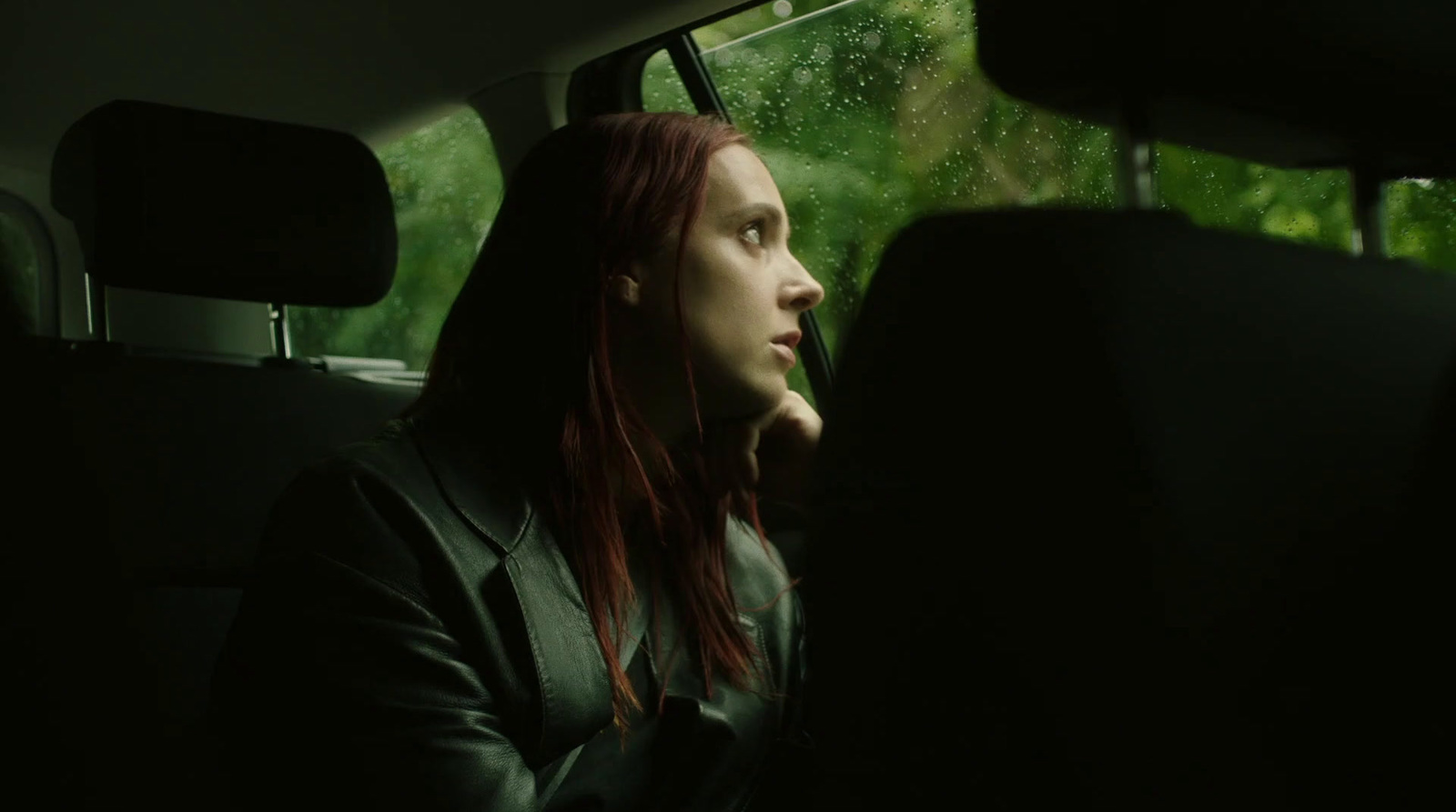 a woman sitting in the back seat of a car