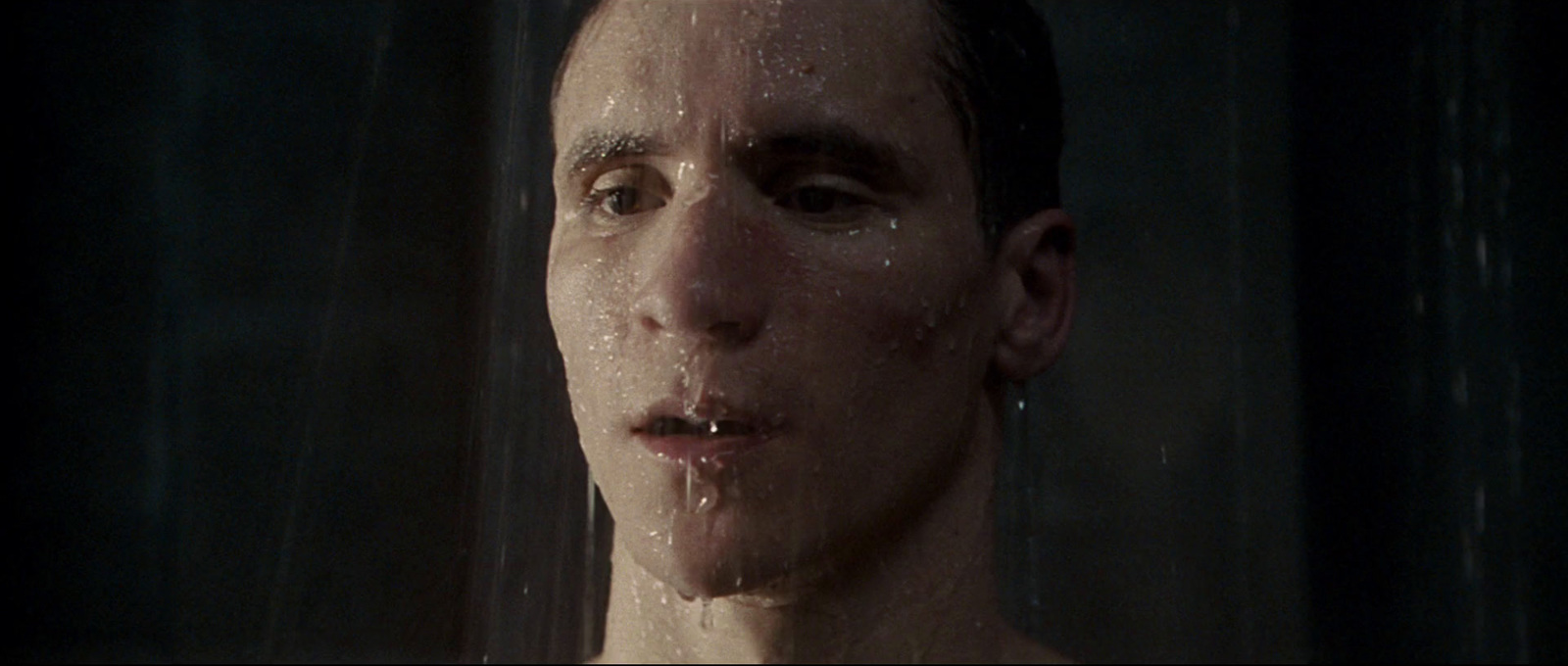 a man is standing in the shower with his tongue out