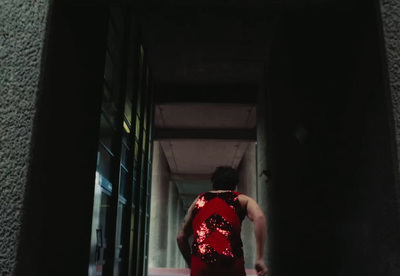 a woman in a red dress walking down a hallway