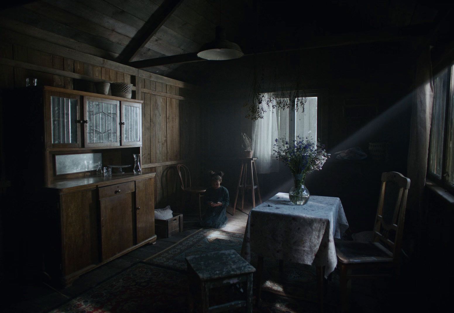 a dark room with a table and chairs