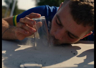 a man blowing out a cigarette on top of a table