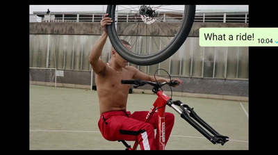 a shirtless man is holding a bicycle over his head