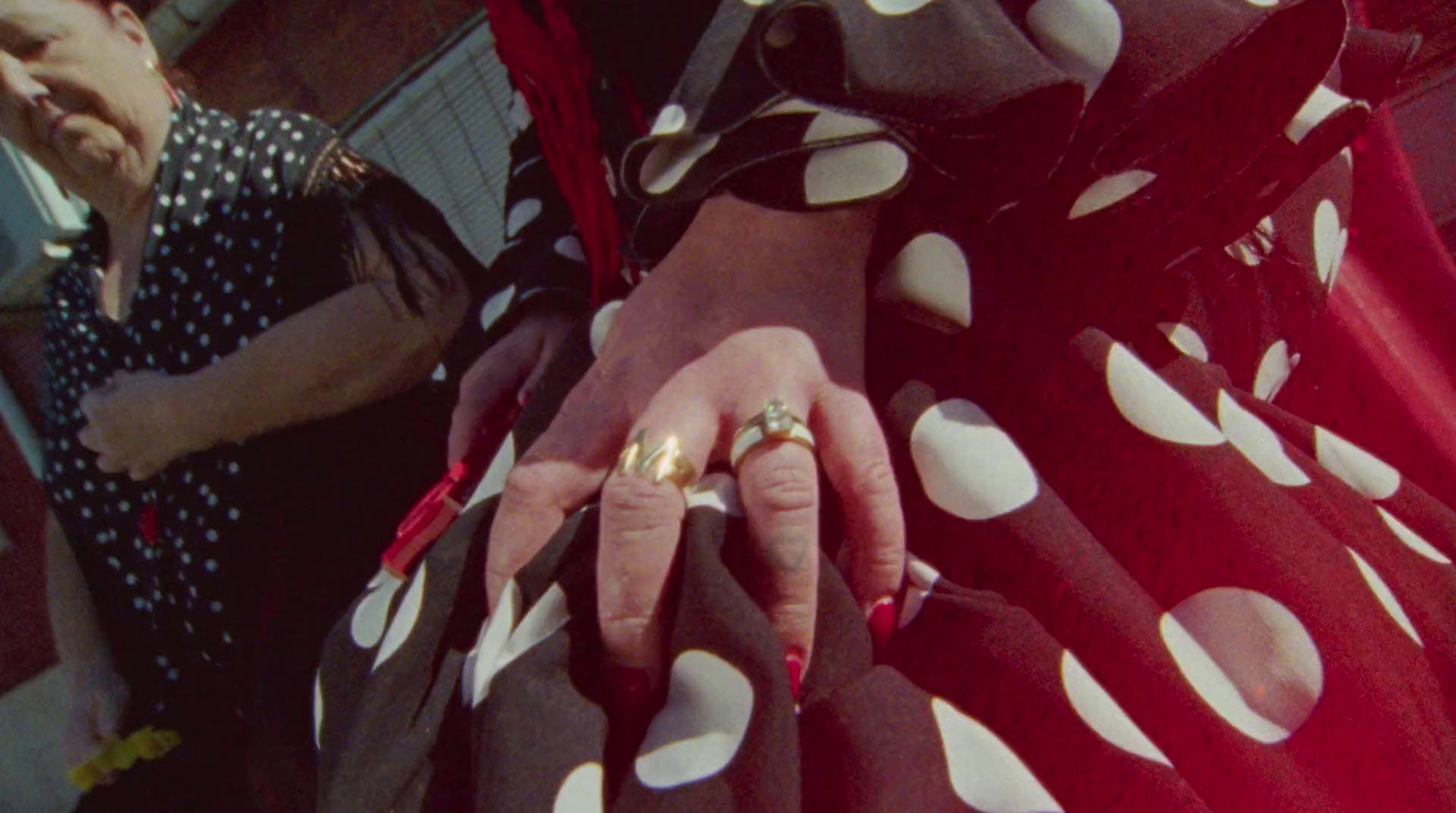 a woman in a polka dot dress holding a ring