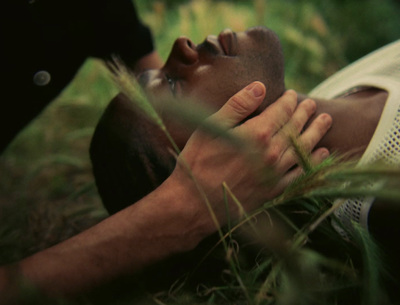 a man laying in the grass with his hands on his face