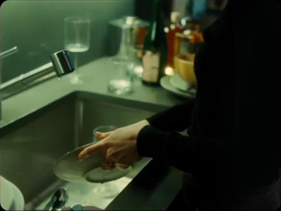 a woman washing dishes in a kitchen sink