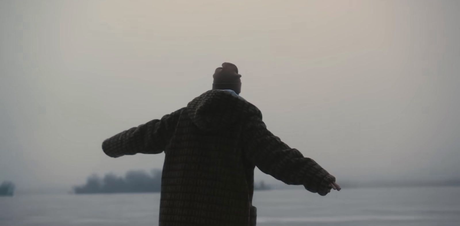 a man standing in front of a body of water