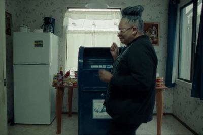 a woman standing in a kitchen next to a refrigerator